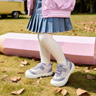 Child wearing purple EBMINI BREEZE wide-toe sneakers at the park
